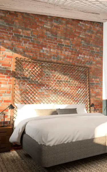 Vista interna di una camera d'albergo con letto, tavolo e sedie.