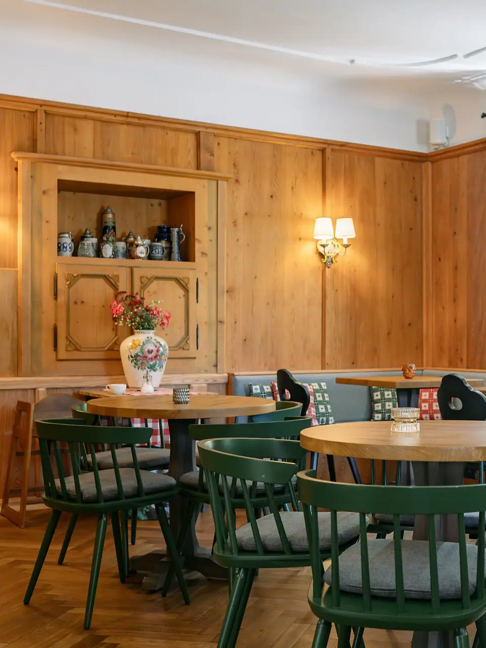 In una stanza accogliente con pareti in legno, c'è un tavolo con un vaso pieno di fiori.